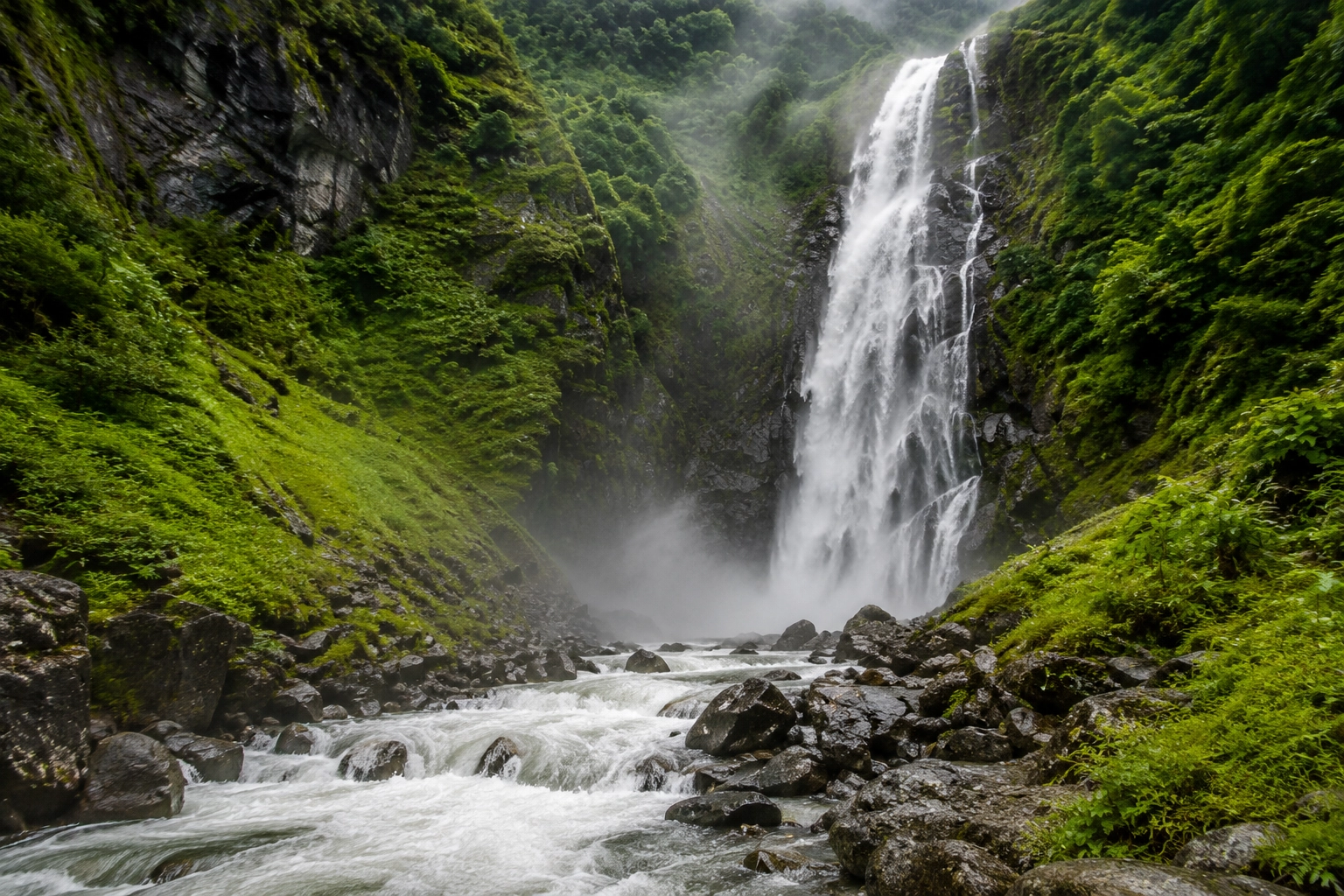 Waterfall and misty mountain view in Valley of Flowers trek